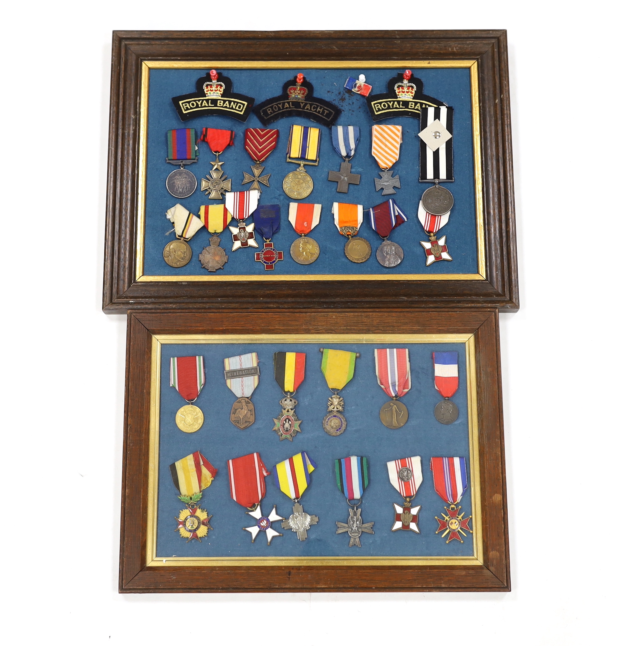 Twenty-seven medals and awards mounted in oak frames, including; French 1939-45 War Medal, Poland Lenino Cross 1943, Romanian Commemorative Medal, Belgium Red Cross Medal, etc. together with cloth shoulder titles for the